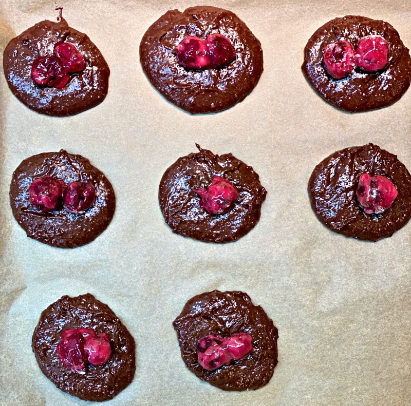 Chocolate Crispy Cookies topped with cherries baked in oven