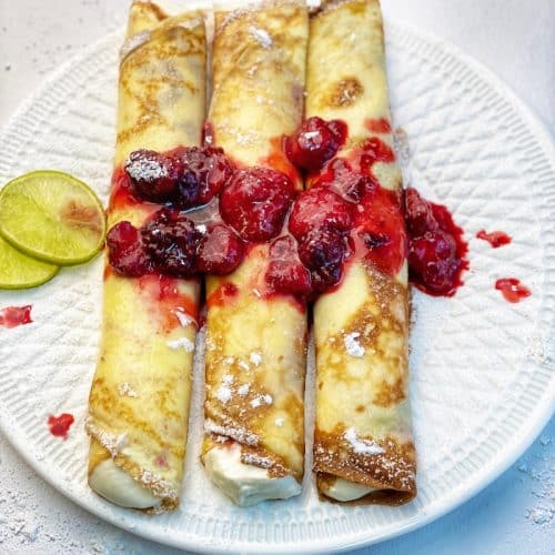 sweet crepes with berry gem on white plate
