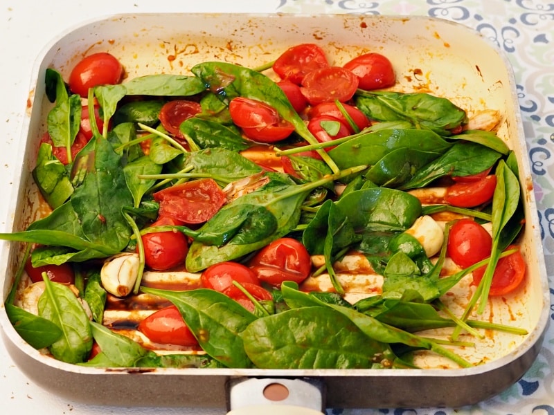 grill pan with spinach cherry tomatoes and garlic