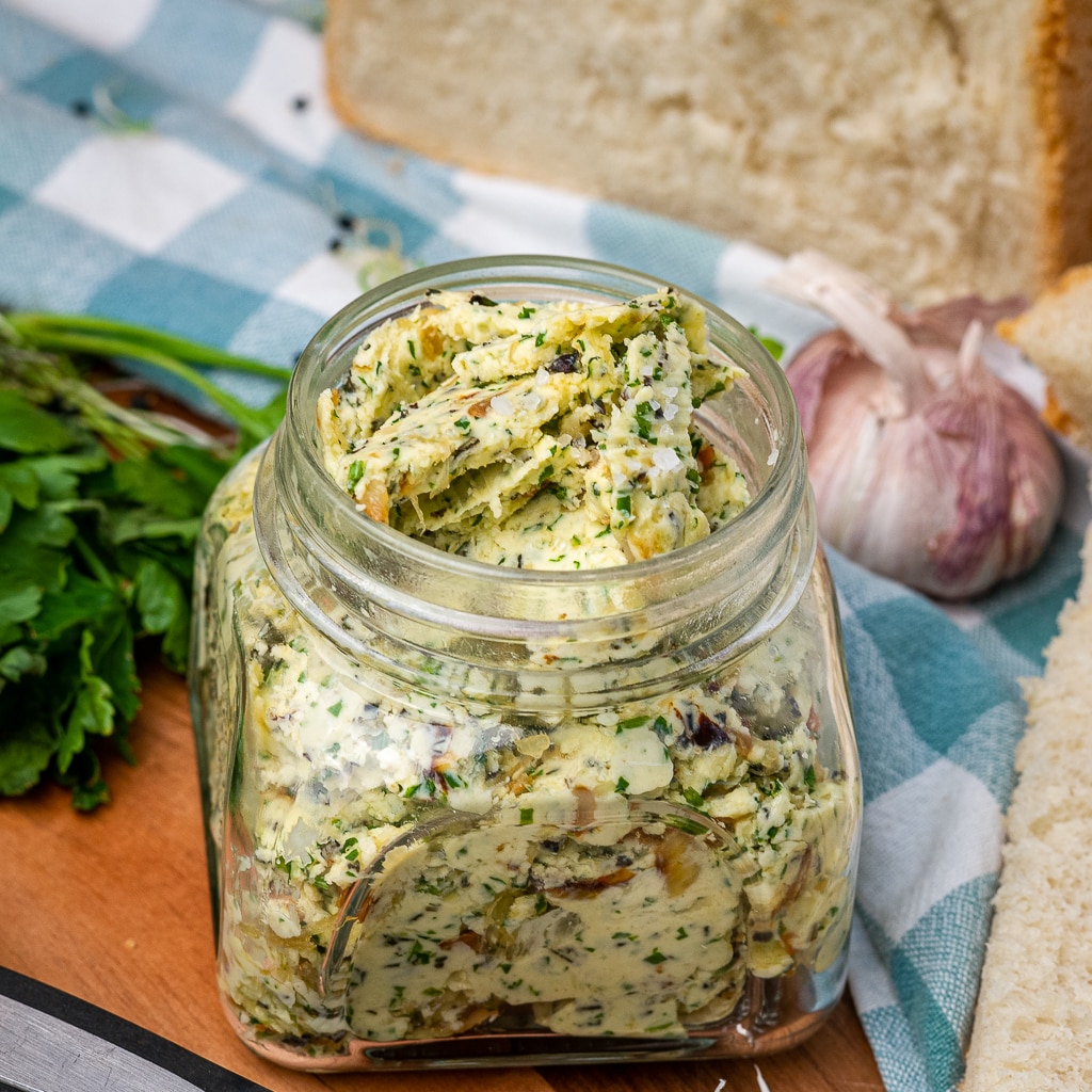 jar with homemade garlic butter with herbs