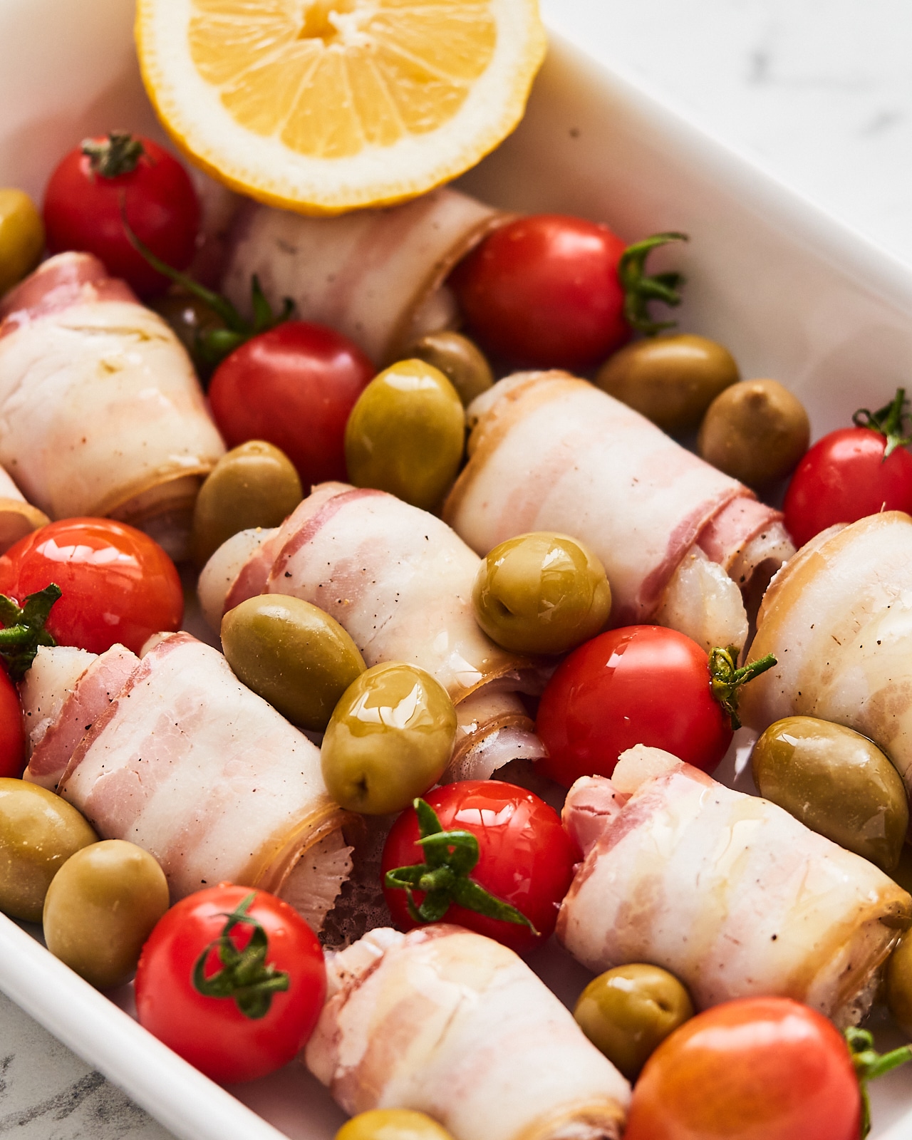 cod and bacon wraps with olives and tomatoes