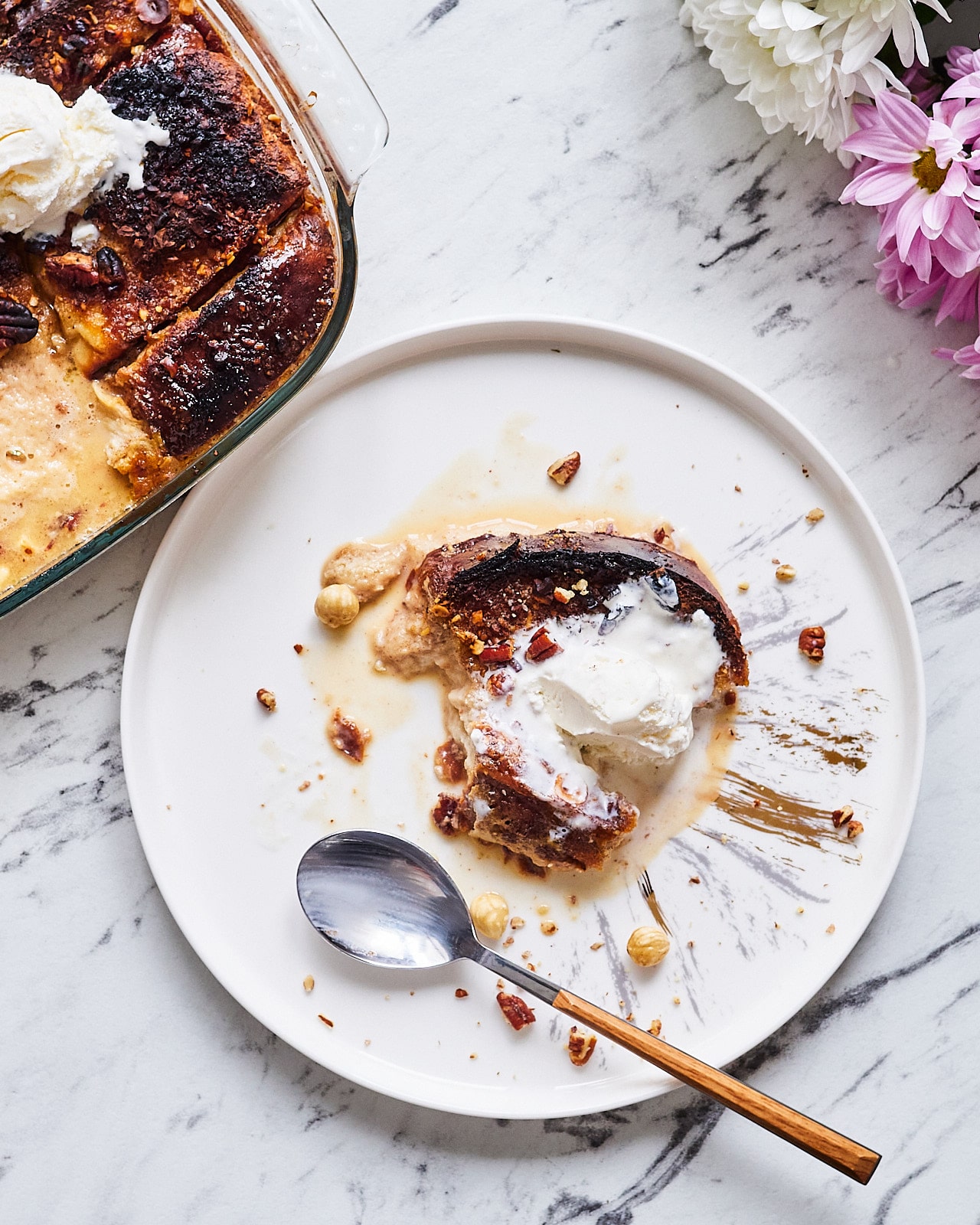 Serve the french toast warm, drizzled with delicious bourbon syrup, and topped with vanilla ice cream.